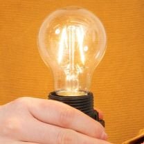 Hand hält leuchtendes LED-Leuchtmittel
